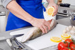 Frau bereitet Fisch zu - Zitronensaft