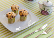 Chocolate chip muffins on white plate and green striped tableclo
