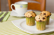 Chocolate chip muffins on white plate and green striped tableclo