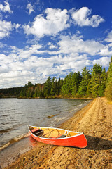 Wall Mural - Red canoe on lake shore