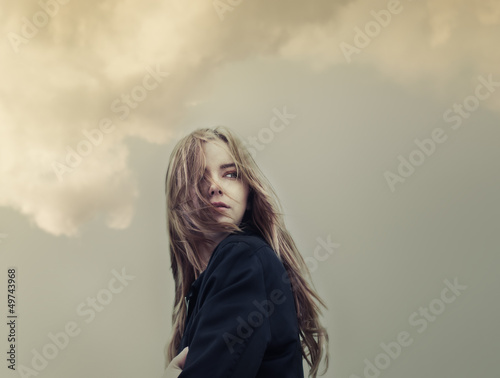 Fotografering beautiful young woman on a background of clouds