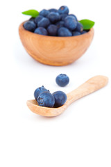 Wall Mural - fresh blueberry in a wooden spoon, over a white background.