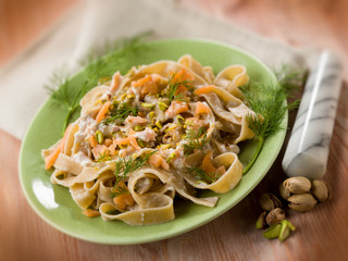 Wall Mural - pasta with salmon pistachio and cream sauce, selective focus