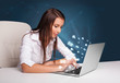 © ra2 studio - Young lady sitting at dest and typing on laptop with message ico