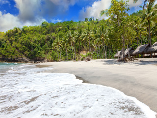 View from a sandy beach on rocks at ocean. Indonesia, Bali