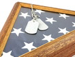Vintage military dog tags on wood flag case and American Flag