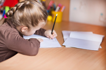 Cute little girl writing her homework