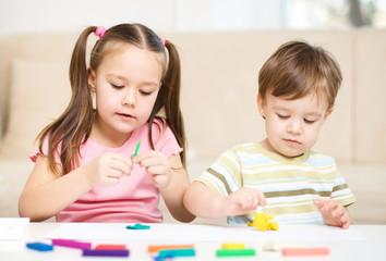 Wall Mural - Sister and brother are playing with plasticine