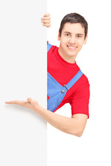 Wall Mural - A smiling repairman showing on a blank panel