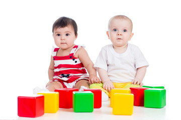 Wall Mural - two babies or kids playing together with color toys