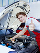 Satisfied car mechanic shows thumb up for a good job