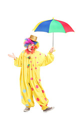 Sticker - Full length portrait of a cheerful clown holding a colorful umbr