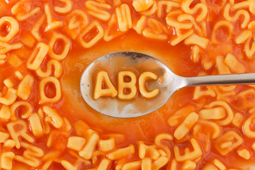 Pasta shaped ABC letters in tomato sauce on a spoon