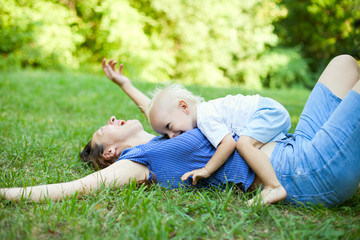 Wall Mural - Mother and son having fun on the grass in park