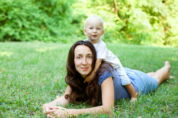 Wall Mural - Portrait of a mother lying on the lawn with her son