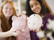 © JGI/Jamie Grill/Blend Images - Friends holding piggy banks