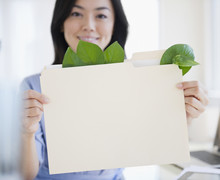 Japanese Businesswoman Holding Folder Containing Leaves