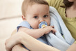 © Mike Kemp/Blend Images - Caucasian baby boy with pacifier in mother's arms