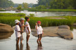 © John Henley/Blend Images - Woman teaching children how to fly fish on river