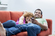 © Inti St Clair/Blend Images - Mixed race couple laying on sofa looking at cell phone