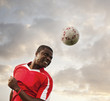 © Mike Kemp/Blend Images - Black soccer player heading the ball