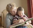 © Mike Kemp/Blend Images - Caucasian grandmother reading book to grandson
