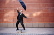 © Peathegee Inc/Blend Images - Caucasian businessman holding umbrella and balancing on board