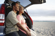 © Peathegee Inc/Blend Images - Black couple sitting on hatchback enjoying the beach