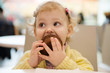 © spass - Cute girl eating muffins in cafe