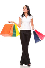 Portrait of young woman carrying shopping bags against white bac