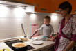 © Arkady Chubykin - Mother with toddler at kitchen