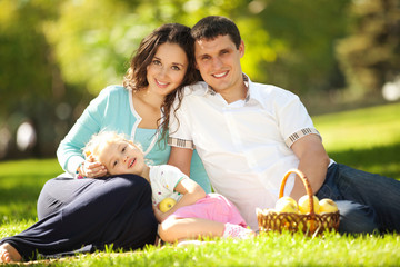 Wall Mural - Happy family having a picnic in the green garden