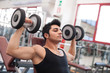 © pio3 - Young man exercising with dumbbells in a gym.