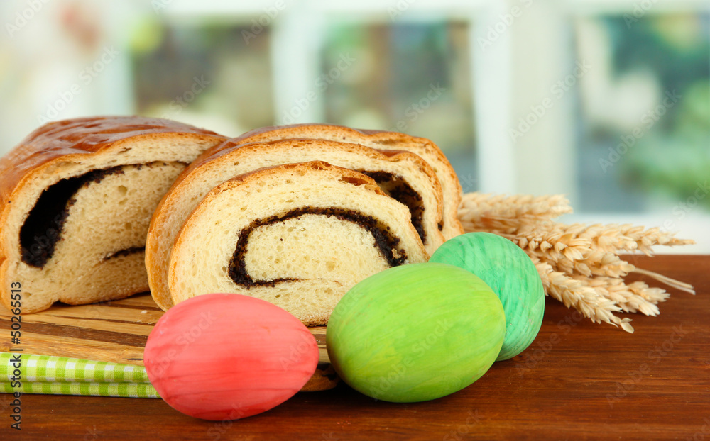 Loaf with poppy seed on cutting board, on bright background
