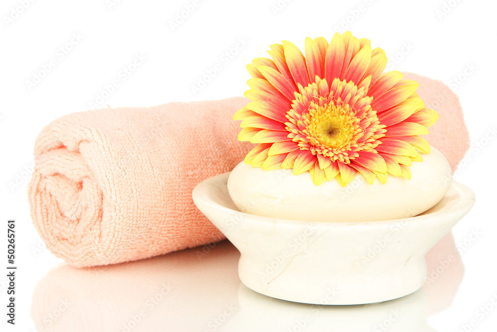Rolled pink towel, soap bar and beautiful flower isolated