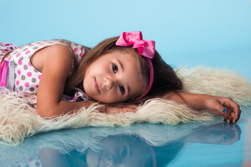 Wall Mural - cute little girl on blue background