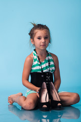 Wall Mural - little girl wearing big mothers shoes
