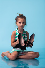 Wall Mural - little girl wearing big mothers shoes