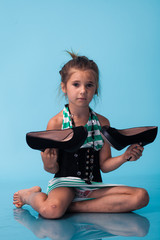 Wall Mural - little girl wearing big mothers shoes