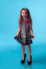 Wall Mural - little girl wearing big mothers shoes