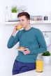 young man drinking a glass of orange juice
