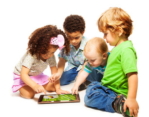 Four little kids playing tablet