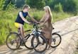 © Konstantin Kulikov - guy and girl by bicycles on the rural road in summer evening