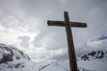 cross on top of swiss mountain in winter