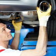 Motor mechanic fixing the exhaust system of a car