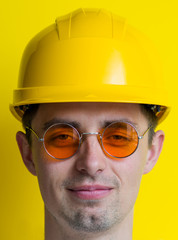 Wall Mural - Engineer in a suit and a helmet on a yellow background