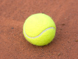 Fototapeta  - Tennis ball close up on red ground