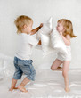 © Ermolaev Alexandr - happy laughing brother and sister having a pillow fight in bed
