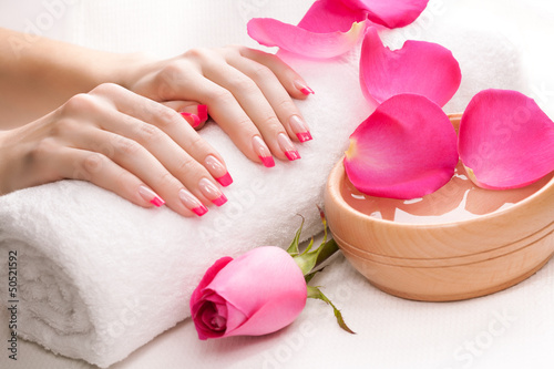 Fototapeta na wymiar hands with fragrant rose petals and towel. Spa