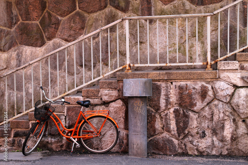 czerwony-miejski-rower-na-kamiennym-tle-ze-schodami